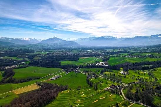 Vue aérienne du golf d'Ésery et de la plaine du Genevois, avec le Môle et les Alpes en arrière-plan